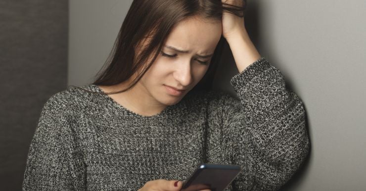 upset teen with phone