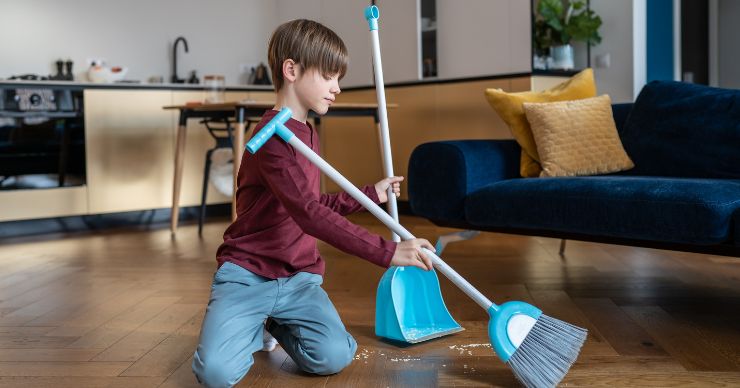 boy sweeping the floor